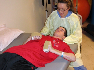 man in red getting a physical therapy from a nurse
