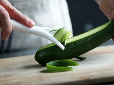 Woman cutting zucchini on chopping board
