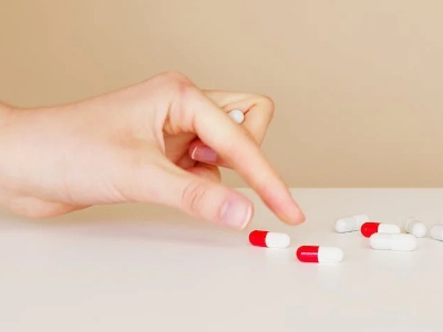 Woman taking pills on white table