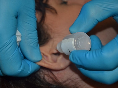 doctor using eardrops on a patients ear