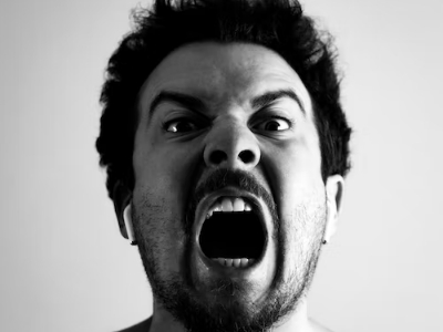man showing angry facial act on a grayscaled photo